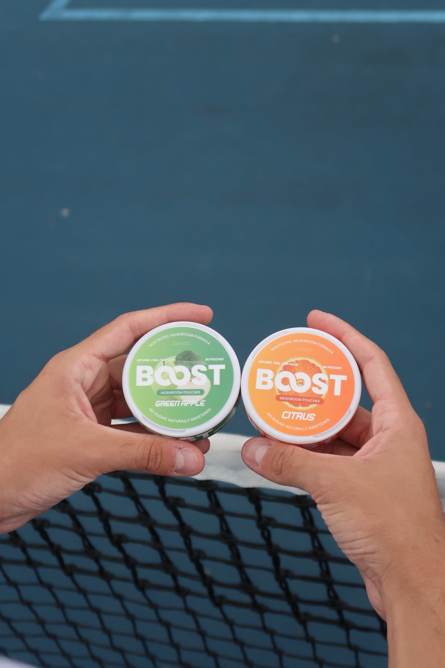 Two containers labeled 'BOOST' held by a hand against a blue background